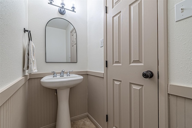 bathroom featuring a sink and a wainscoted wall