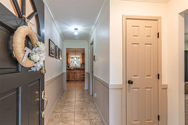 hall featuring crown molding, wainscoting, and a sink