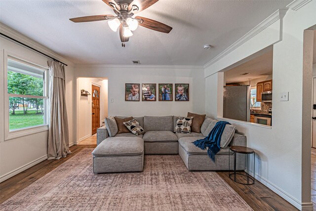living area featuring baseboards, ornamental molding, and wood finished floors