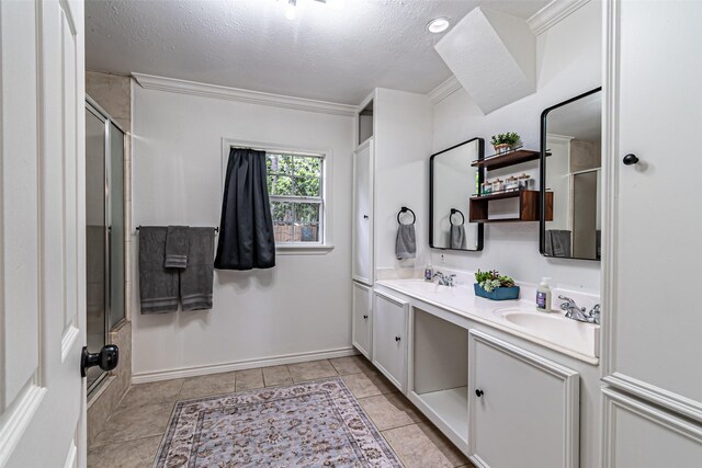 full bath featuring an enclosed shower, double vanity, a textured ceiling, and a sink
