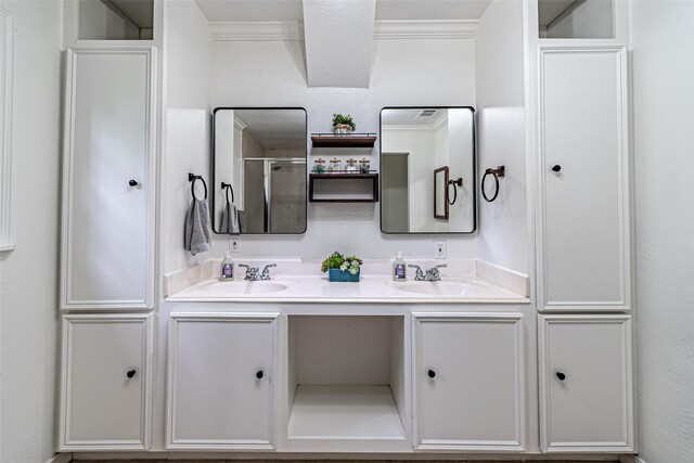 full bath with double vanity, a sink, a shower, and ornamental molding