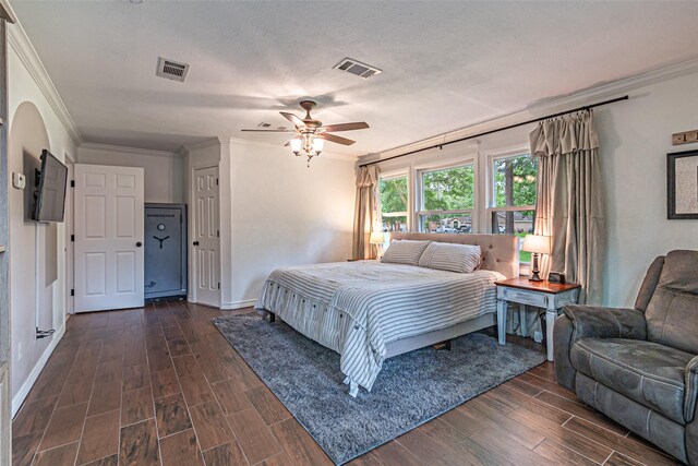 bedroom featuring crown molding, visible vents, and dark wood finished floors