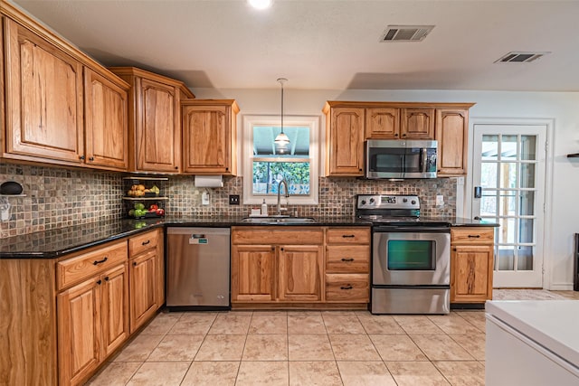 kitchen featuring visible vents, a sink, tasteful backsplash, and stainless steel appliances