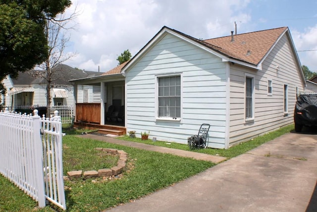 bungalow-style home with fence and a shingled roof