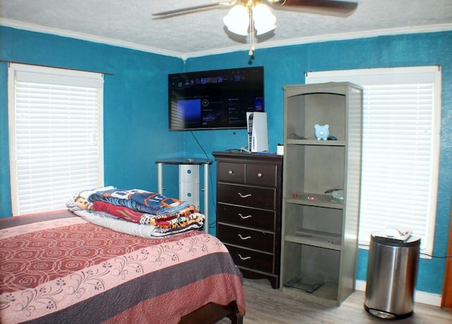 7721 Brumblay St, Houston, TX 77012 - bedroom featuring ornamental molding, a ceiling fan, and wood finished floors