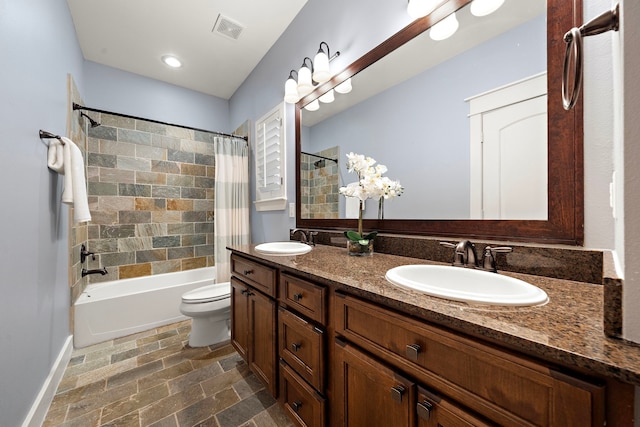 bathroom featuring stone finish floor, visible vents, a sink, and shower / bath combo