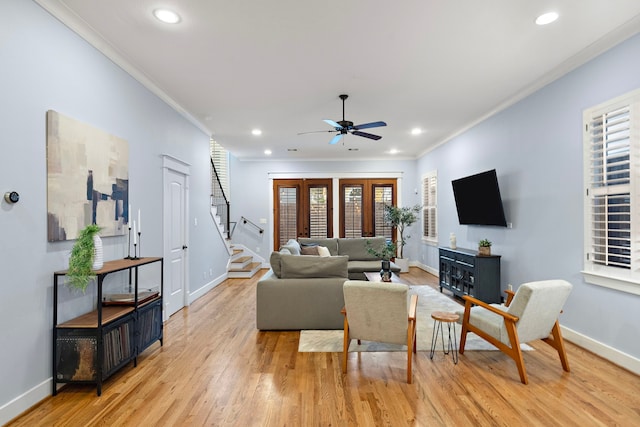 living room featuring baseboards, ornamental molding, and a ceiling fan