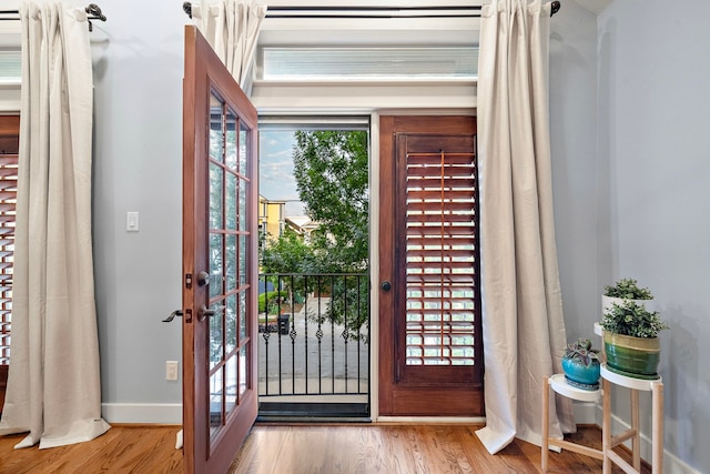 entrance foyer featuring baseboards, french doors, and wood finished floors