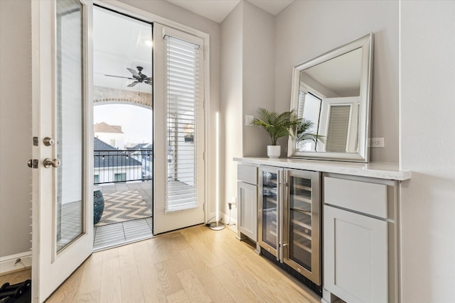 doorway featuring beverage cooler, a ceiling fan, and light wood-type flooring