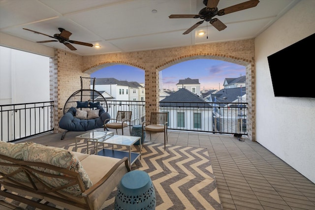 balcony featuring a residential view, ceiling fan, and an outdoor living space