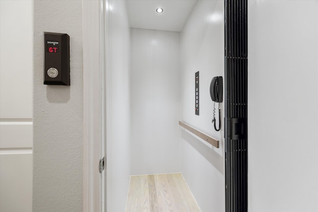 details with recessed lighting, elevator, and wood finished floors