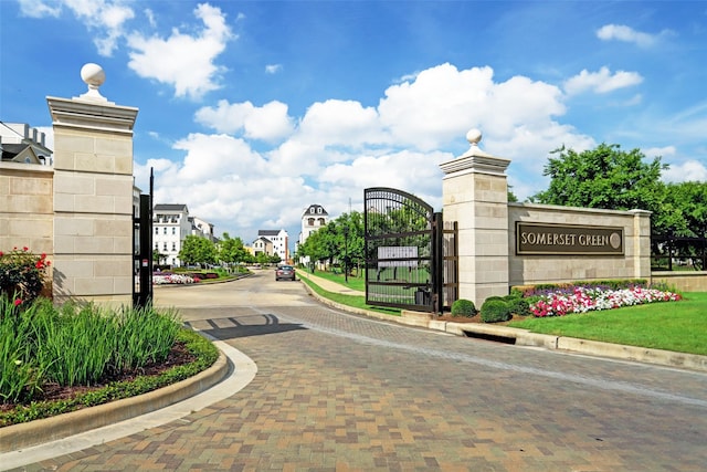 community sign featuring a residential view and a gate