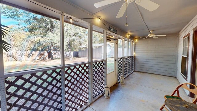 unfurnished sunroom with ceiling fan