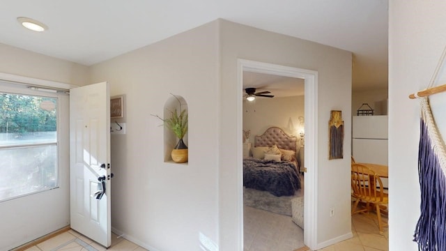 doorway to outside with light tile patterned floors, baseboards, and ceiling fan