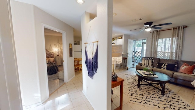 living room with a ceiling fan, visible vents, and light tile patterned floors