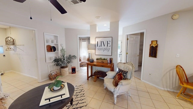 interior space featuring visible vents, baseboards, built in shelves, a ceiling fan, and light tile patterned floors
