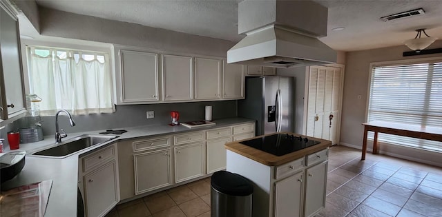 532 S Rivershire Dr, Conroe, TX 77304 - kitchen featuring stainless steel fridge, a sink, island exhaust hood, plenty of natural light, and a textured ceiling