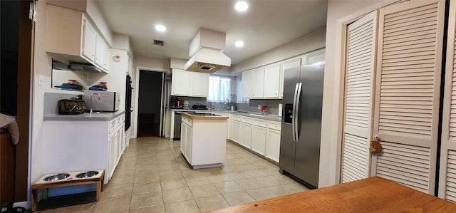 532 S Rivershire Dr, Conroe, TX 77304 - kitchen with appliances with stainless steel finishes, light tile patterned floors, white cabinets, a sink, and recessed lighting