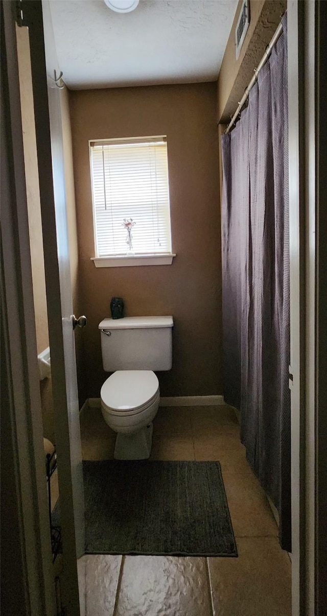 532 S Rivershire Dr, Conroe, TX 77304 - bathroom with toilet, tile patterned floors, a shower with curtain, and baseboards