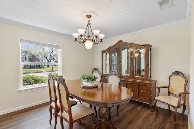 dining space featuring visible vents, wood finished floors, baseboards, a notable chandelier, and ornamental molding