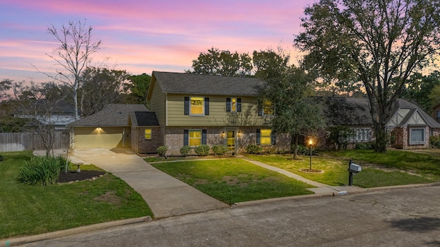 colonial inspired home featuring fence, a front yard, brick siding, concrete driveway, and an attached garage