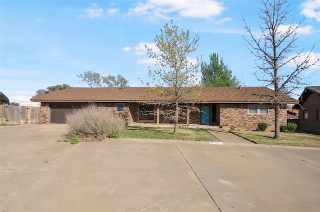 single story home featuring fence, driveway, a front yard, and a garage