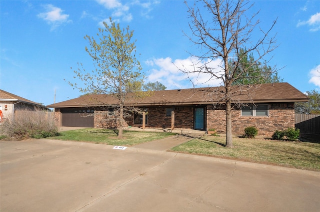 single story home featuring brick siding, a garage, fence, and a front yard