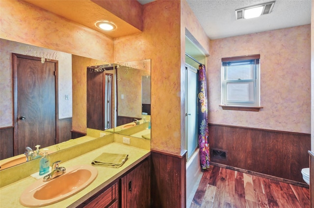 full bathroom featuring visible vents, wood finished floors, vanity, toilet, and shower / bath combo with shower curtain