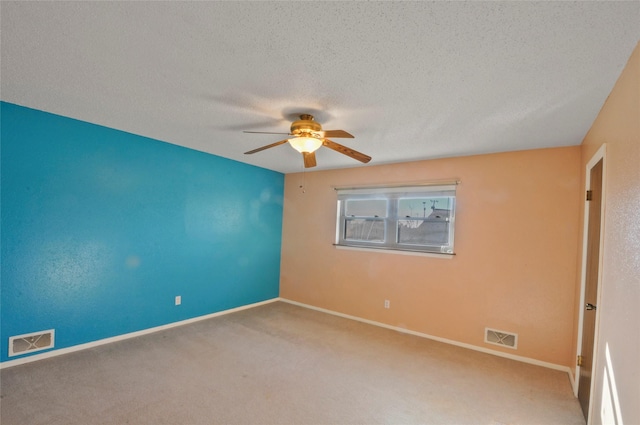 unfurnished room with a ceiling fan, a textured ceiling, visible vents, and baseboards