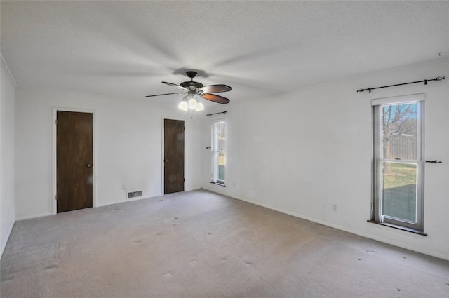 spare room featuring carpet, a ceiling fan, and a textured ceiling