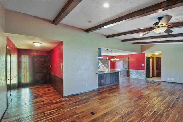 interior space featuring a textured ceiling, wood finished floors, and beam ceiling