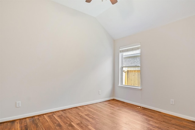 unfurnished room featuring a ceiling fan, baseboards, vaulted ceiling, and light wood-type flooring