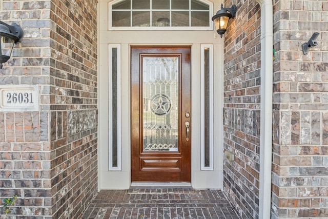doorway to property with brick siding