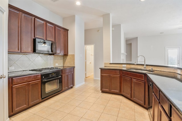 kitchen featuring recessed lighting, a sink, backsplash, and black appliances