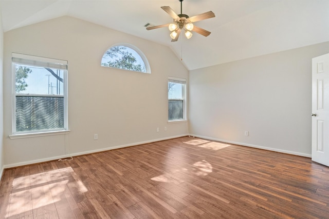 empty room with baseboards, a ceiling fan, vaulted ceiling, and wood finished floors