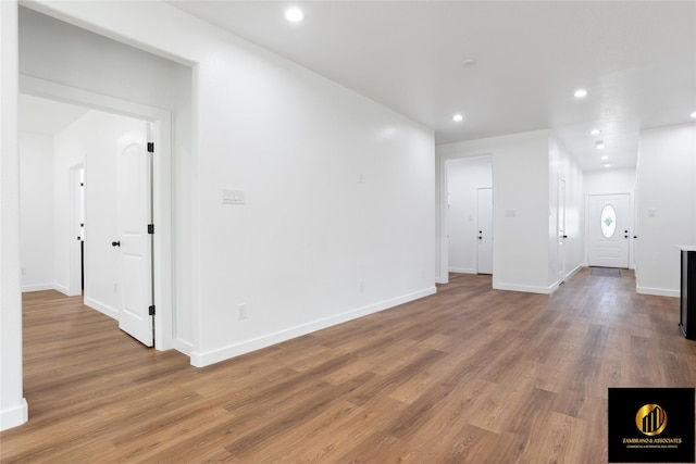spare room featuring recessed lighting, baseboards, and wood finished floors
