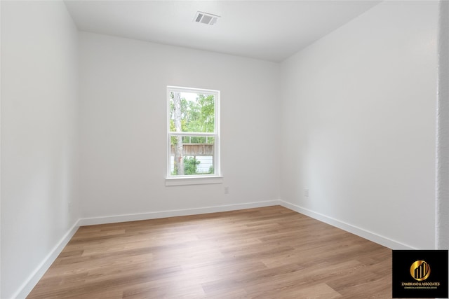 unfurnished room with visible vents, light wood-style flooring, and baseboards