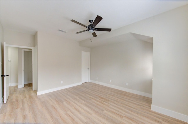 spare room with ceiling fan, visible vents, baseboards, and light wood-type flooring