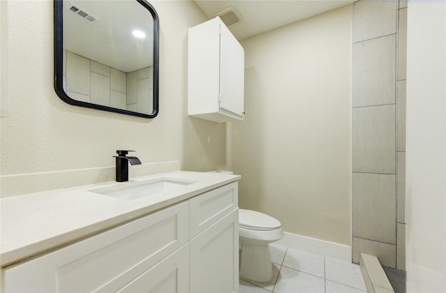bathroom featuring visible vents, vanity, toilet, baseboards, and tile patterned floors