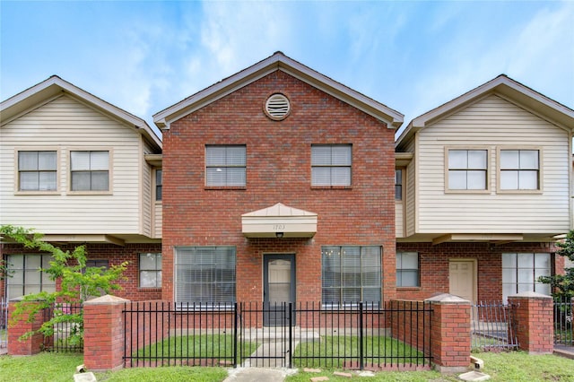view of front of property featuring a fenced front yard and brick siding