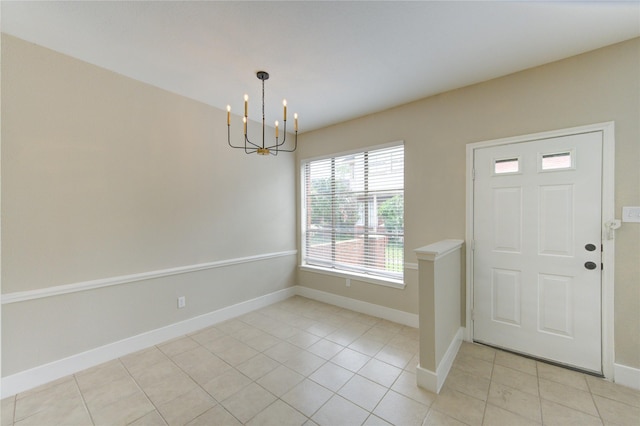 foyer entrance with light tile patterned flooring, baseboards, and an inviting chandelier