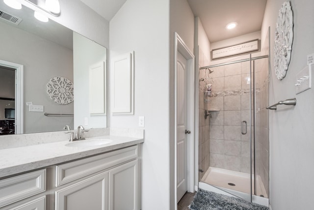 full bath with visible vents, vanity, and a shower stall