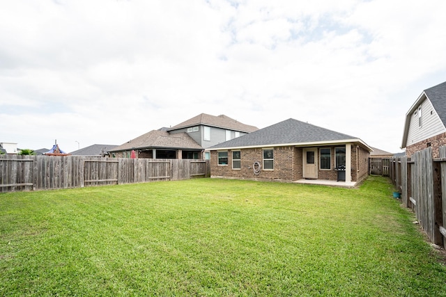 rear view of house with brick siding, a lawn, and a patio