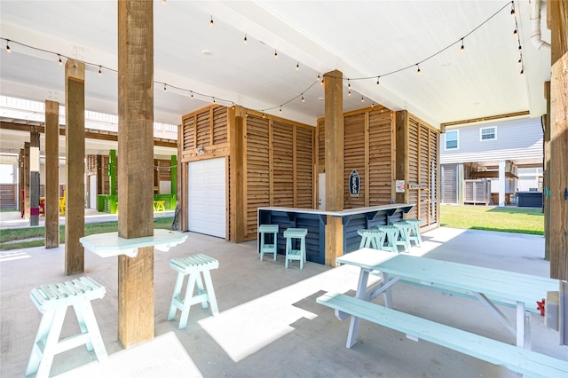 view of patio / terrace with an attached garage and outdoor dry bar