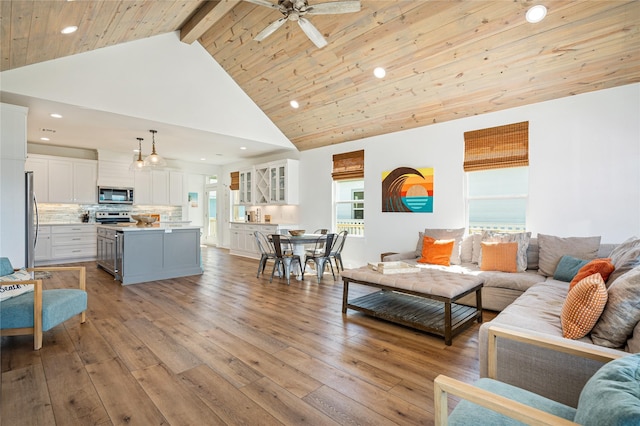 living room with recessed lighting, high vaulted ceiling, ceiling fan, and light wood-type flooring