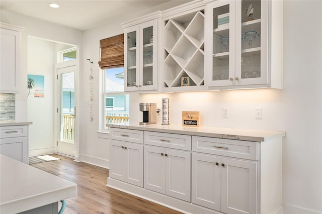bar with light wood-style floors, recessed lighting, and baseboards