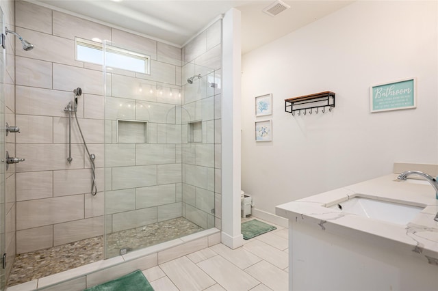full bath featuring visible vents, a sink, a stall shower, and double vanity