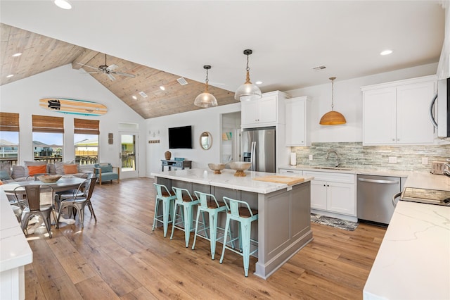 kitchen with a center island, open floor plan, appliances with stainless steel finishes, and light wood-type flooring