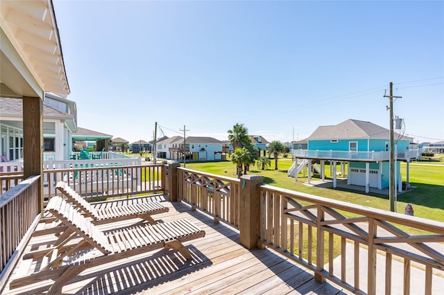 deck featuring a lawn, a residential view, stairs, and a playground