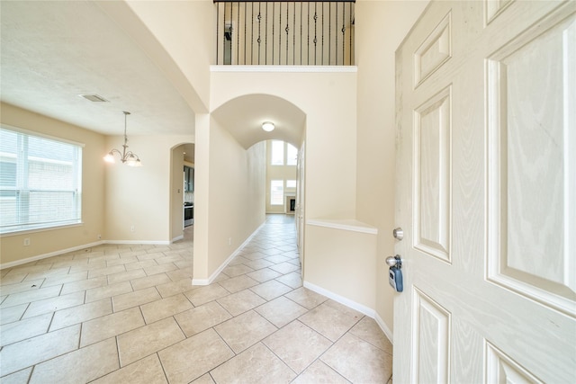 24618 Malca Manor Dr, Katy, TX 77493 - foyer entrance featuring light tile patterned floors, arched walkways, a notable chandelier, and a wealth of natural light